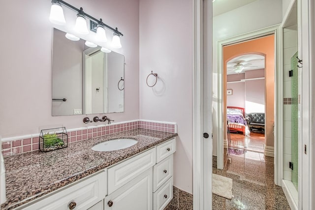 bathroom featuring a ceiling fan, granite finish floor, and vanity