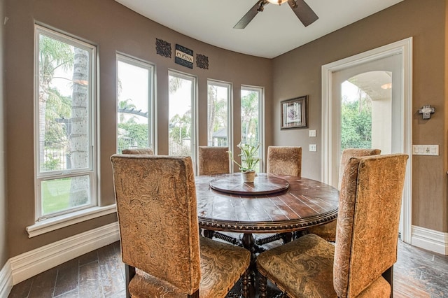 dining space with arched walkways, a wealth of natural light, and baseboards