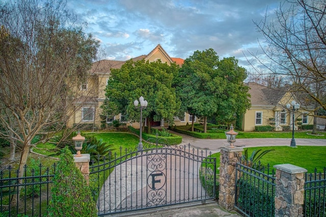 view of front of house with a fenced front yard, a front yard, a gate, and stucco siding