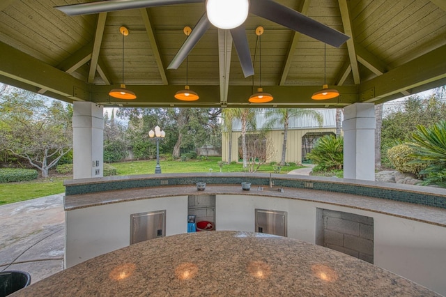 view of patio with a gazebo, outdoor dining space, exterior kitchen, and a sink