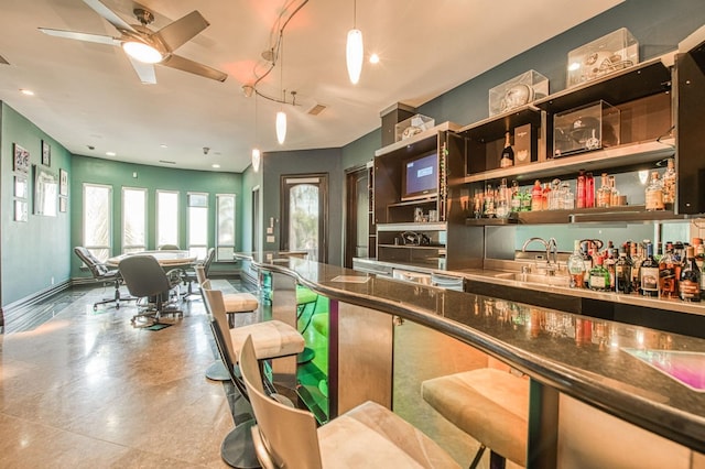 kitchen featuring baseboards, open floor plan, decorative light fixtures, open shelves, and a sink