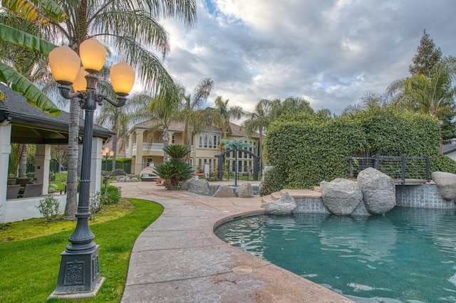 view of swimming pool featuring a yard, a patio, fence, and a fenced in pool