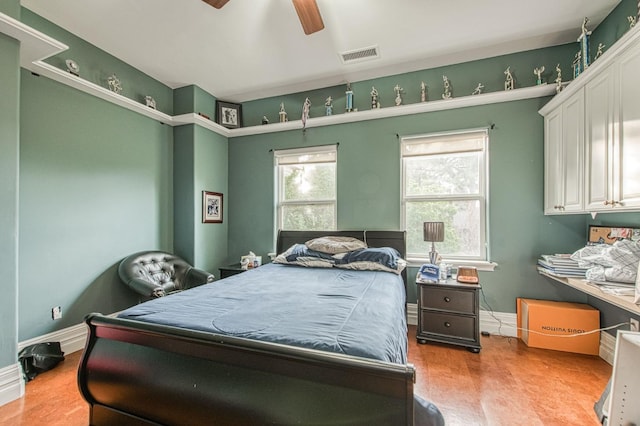 bedroom featuring a ceiling fan, visible vents, baseboards, and wood finished floors