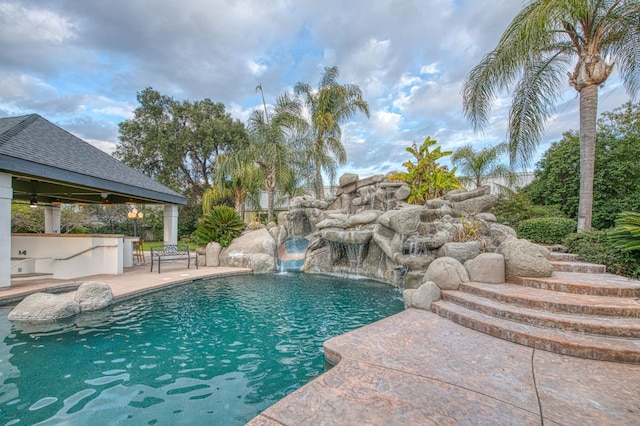 view of swimming pool with a gazebo, outdoor dry bar, a fenced in pool, and a patio