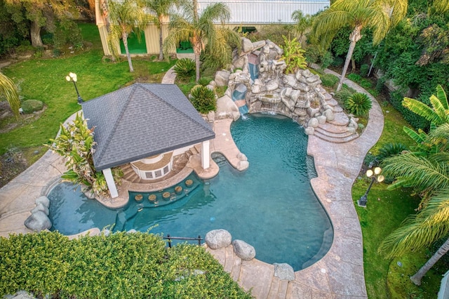 view of pool with a fenced in pool, a patio area, a yard, and a garden pond