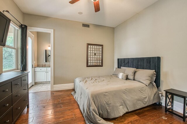 bedroom with wood-type flooring, visible vents, a ceiling fan, ensuite bath, and baseboards