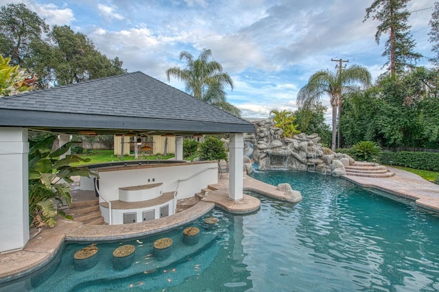 view of swimming pool with outdoor dry bar, a fenced in pool, and a gazebo