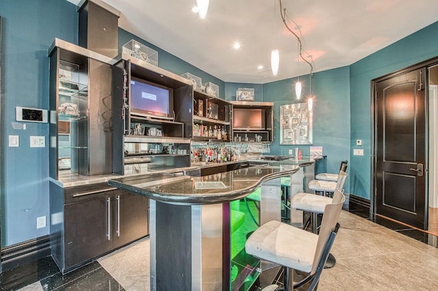 kitchen with a breakfast bar, a kitchen island, baseboards, dark brown cabinets, and open shelves