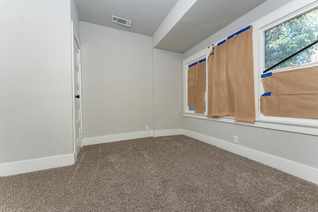 carpeted empty room featuring visible vents and baseboards