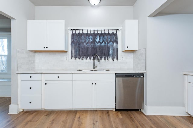 kitchen with light countertops, white cabinetry, a sink, and stainless steel dishwasher