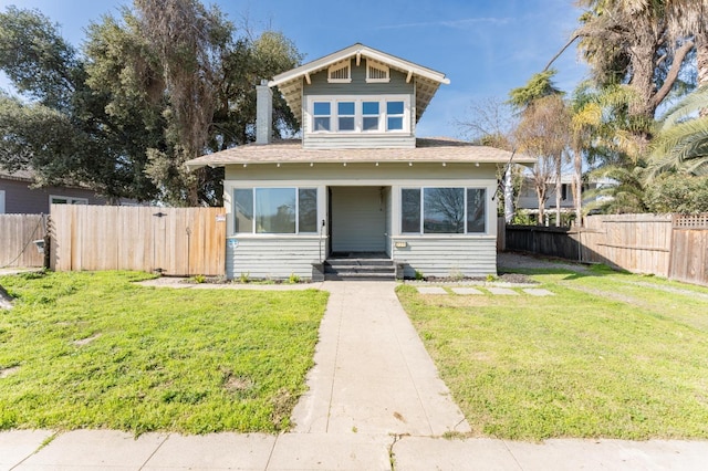 bungalow-style house featuring a gate, fence, and a front yard