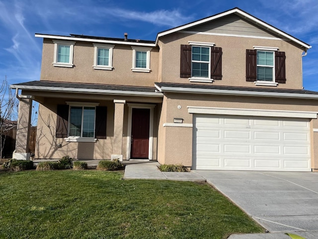 traditional-style home with a garage, driveway, a front lawn, and stucco siding