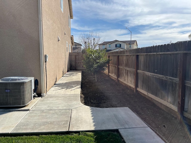 view of yard featuring a patio area, a fenced backyard, and central AC unit