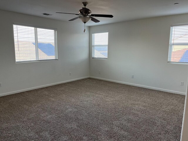 empty room featuring carpet, visible vents, and baseboards