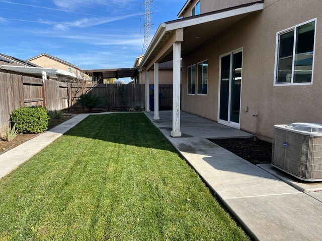 view of yard with central air condition unit, a fenced backyard, and a patio