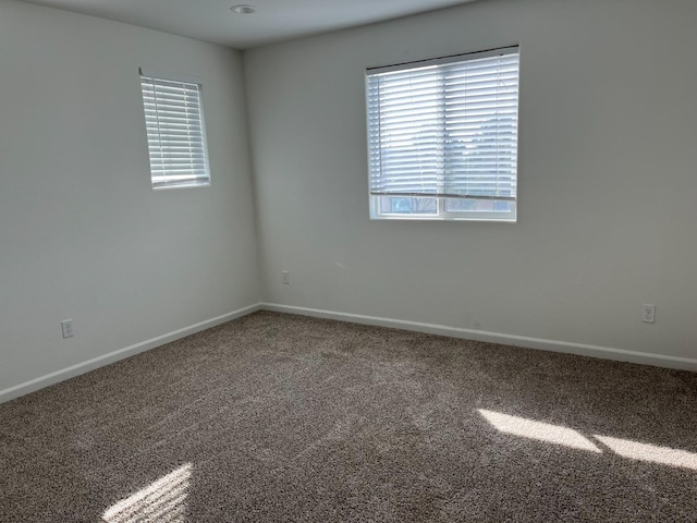 carpeted empty room with baseboards