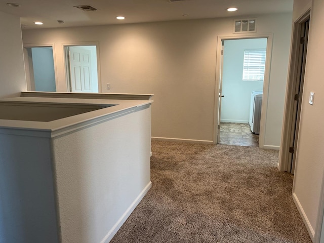 corridor with carpet, visible vents, and baseboards