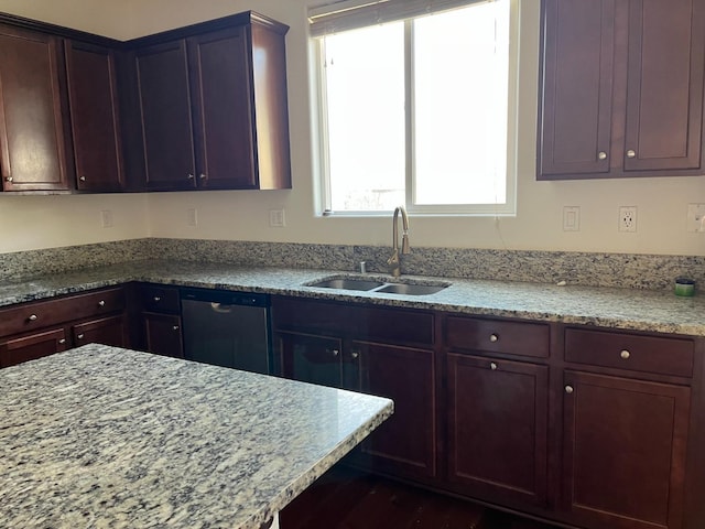 kitchen with dishwasher, light stone counters, and a sink