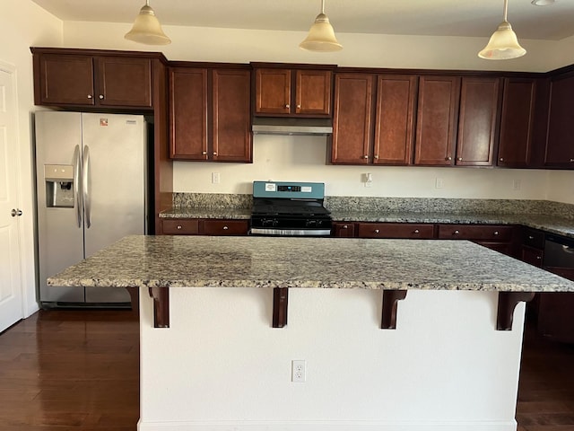 kitchen featuring appliances with stainless steel finishes, a breakfast bar, pendant lighting, and light stone countertops