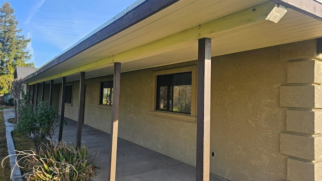 view of side of home featuring a patio and stucco siding