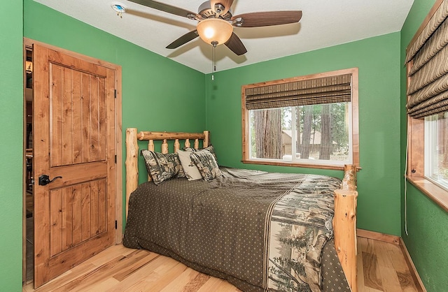 bedroom featuring baseboards, a ceiling fan, and wood finished floors