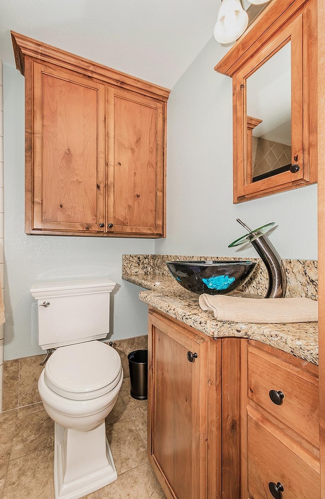 bathroom featuring toilet, tile patterned flooring, and vanity