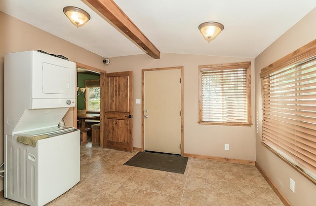 laundry area with laundry area, baseboards, and stacked washing maching and dryer