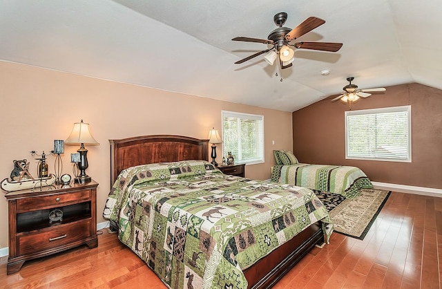 bedroom featuring vaulted ceiling, wood finished floors, a ceiling fan, and baseboards