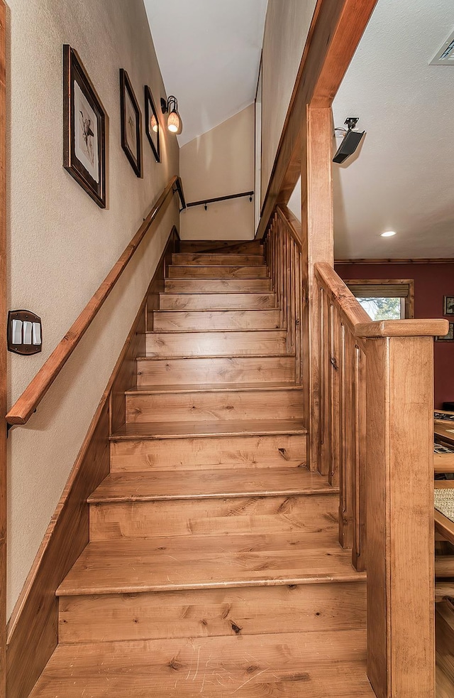 stairway with visible vents and wood finished floors