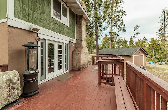 deck featuring a storage unit, an outdoor structure, and french doors