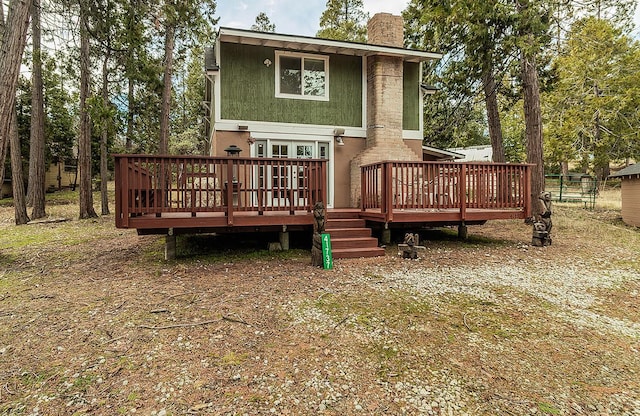 back of property featuring a chimney and a deck