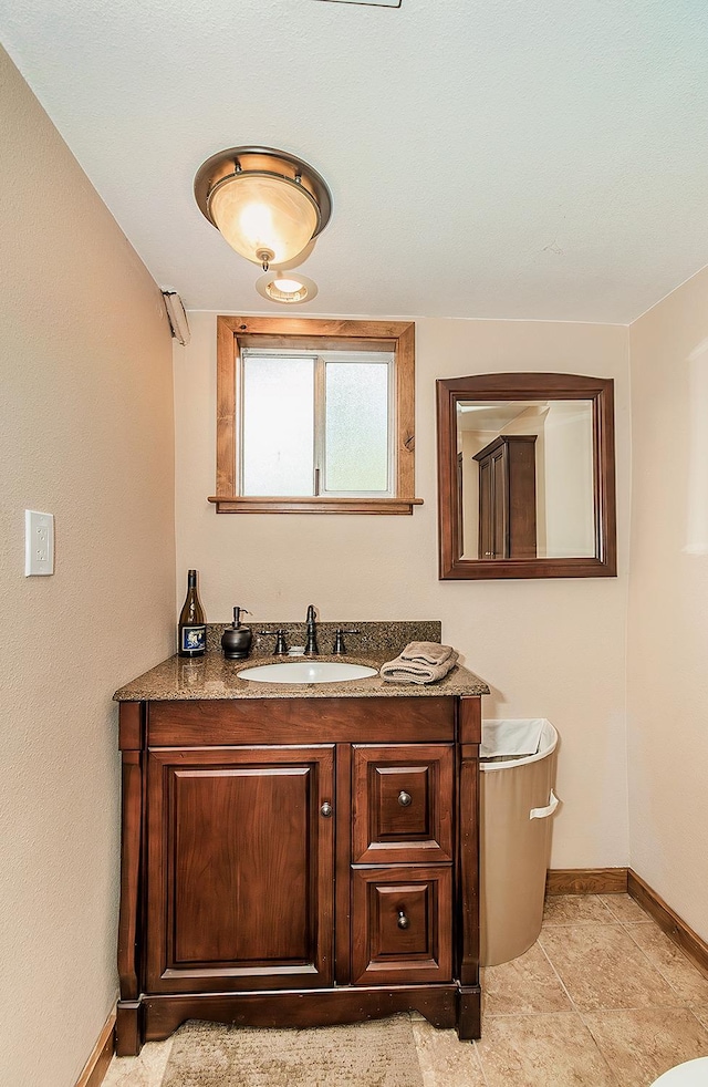 bathroom featuring tile patterned flooring, baseboards, and vanity