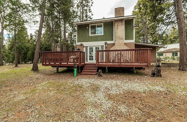 rear view of property with a chimney and a deck