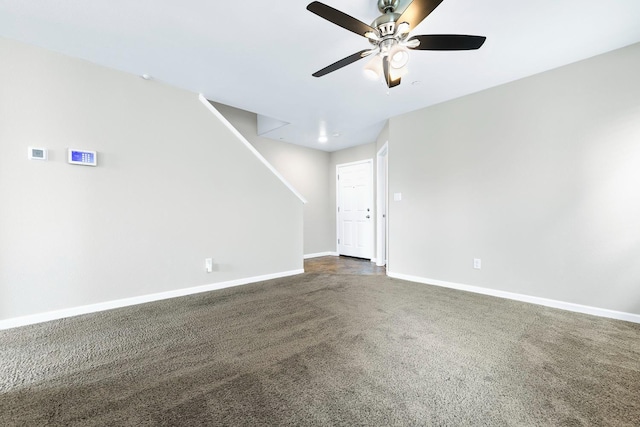 unfurnished living room with ceiling fan, dark carpet, and baseboards