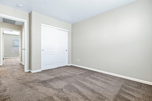 unfurnished bedroom with a closet, carpet flooring, visible vents, and baseboards