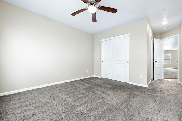 unfurnished bedroom with dark colored carpet, a closet, and baseboards