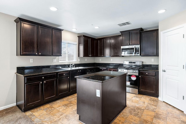 kitchen with visible vents, appliances with stainless steel finishes, dark brown cabinets, and a center island