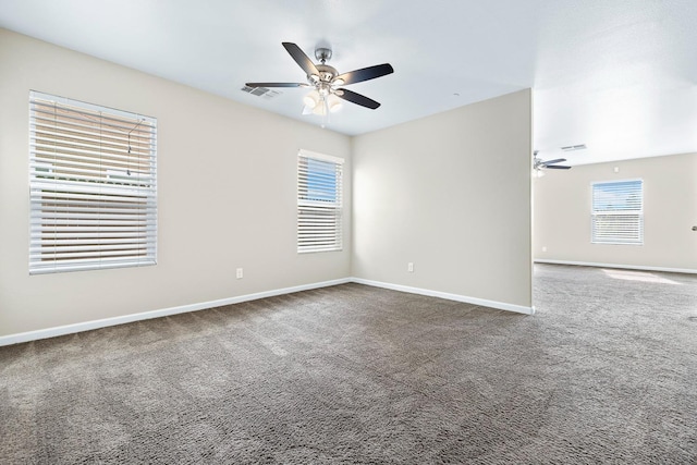 carpeted empty room with ceiling fan, visible vents, and baseboards