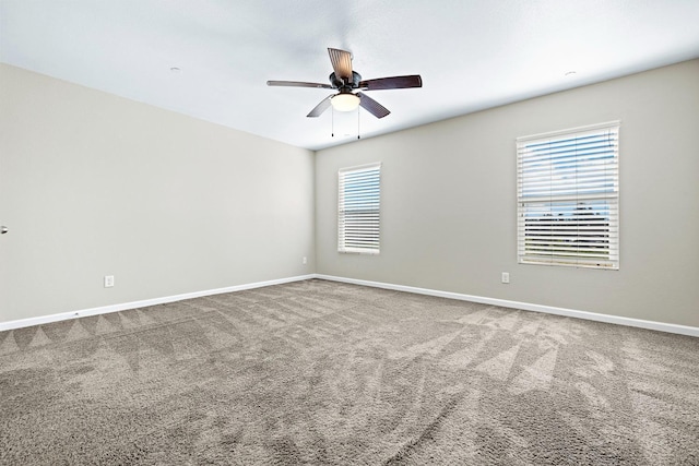 carpeted spare room with ceiling fan and baseboards