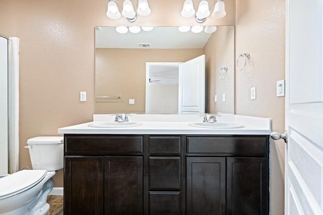 full bathroom with toilet, double vanity, and a sink