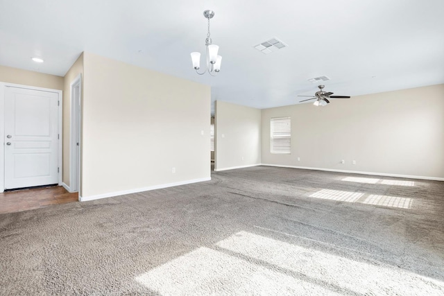 unfurnished room with baseboards, visible vents, dark colored carpet, and ceiling fan with notable chandelier