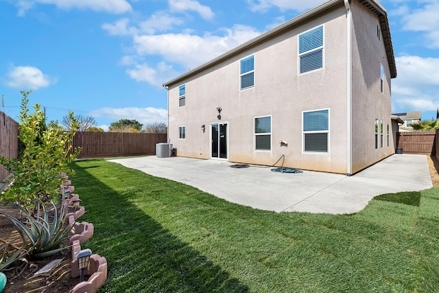 rear view of house featuring a yard, a fenced backyard, central AC, and stucco siding