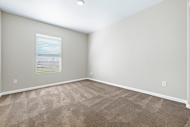 unfurnished room with carpet and baseboards