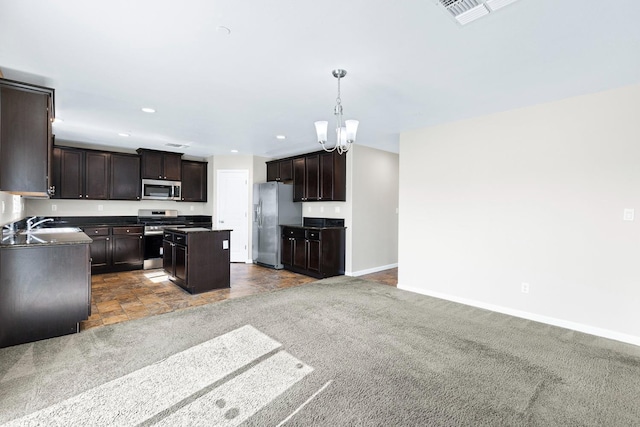 kitchen featuring stainless steel appliances, baseboards, dark brown cabinets, a center island, and decorative light fixtures