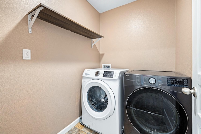 clothes washing area featuring laundry area, independent washer and dryer, and baseboards