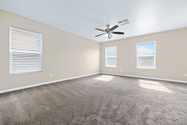 unfurnished room featuring ceiling fan, carpet floors, visible vents, and baseboards