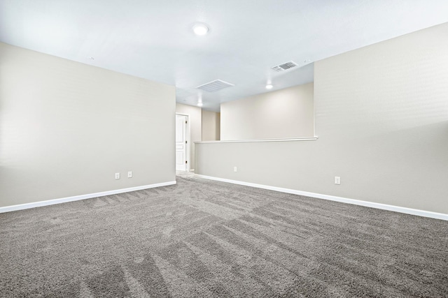 empty room with carpet, visible vents, and baseboards