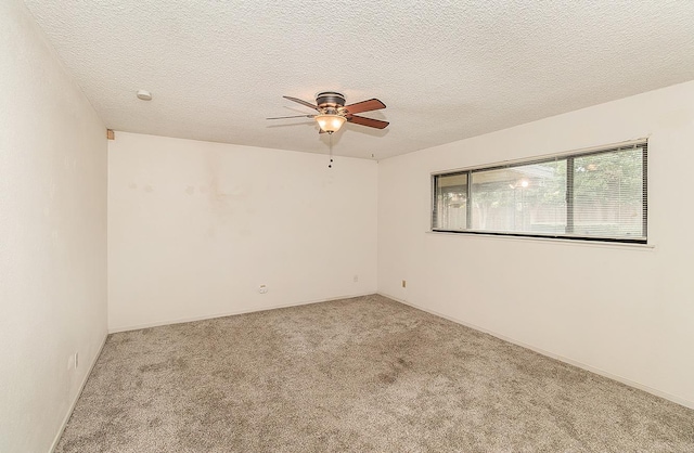 empty room with a ceiling fan, light carpet, and a textured ceiling