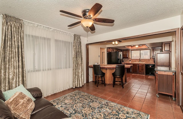 living area featuring dark tile patterned floors and a textured ceiling