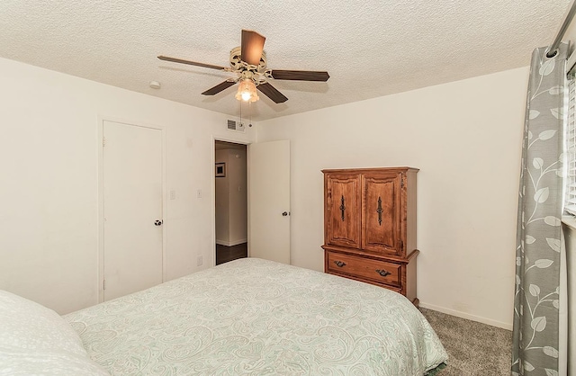 carpeted bedroom with a ceiling fan, baseboards, visible vents, and a textured ceiling